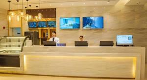two people sitting at a counter with their laptops at City Comfort Inn Yangjiang High-tech Zone Pinggang in Yangjiang