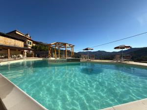 a large swimming pool with blue water at Agriturismo Gli Ulivi in Garlenda