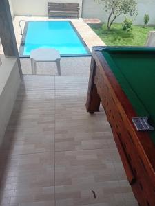 a pool table in front of a swimming pool at Chácara silva in Nova Serrana +9 photos
