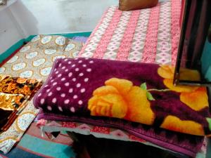 a purple blanket with a flower on it on a bed at Kumbh Mela Vikas home stay in Prayagraj