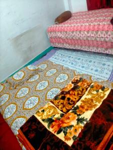 a table with flowers on top of a quilt at Kumbh Mela Vikas home stay in Prayagraj