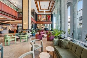 een lobby met banken, tafels en ramen bij Town in Town Hotel Bangkok in Bangkok