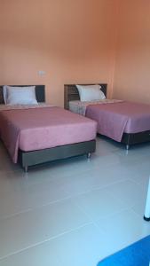two beds sitting next to each other in a room at สำเภาทองรีสอร์ท in Ban Don Sai