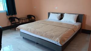 a bedroom with a large bed with white pillows at สำเภาทองรีสอร์ท in Ban Don Sai