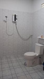 a bathroom with a toilet and a phone on the wall at สำเภาทองรีสอร์ท in Ban Don Sai