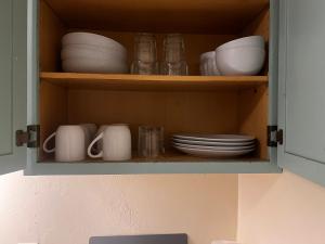 SolStar Suite - Steps From Tucson's NEW Casino في توسان: خزانة مليئة بالأطباق والأطباق والأطباق +6 صور