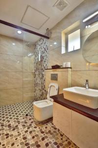 バルカラにあるamaze Beach Resortの洗面台、トイレ、鏡のあるバスルーム