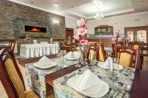 a dining room with a table and chairs and a fireplace at Hotel Irys in Lublin