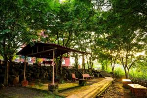 a pavilion with a bench and trees in a park at Rio Royale in Bhimashankar