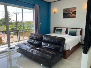 a bedroom with a couch and a bed and a window at 365 Place Maikhao in Ban Mai Salae +24 photos