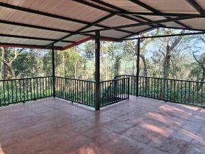 an empty screened porch with a view of the woods at Coffee Courtyard in Kurchi