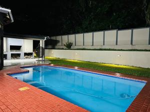 a swimming pool in a backyard at night at Alwande's Guesthouse in Richards Bay
