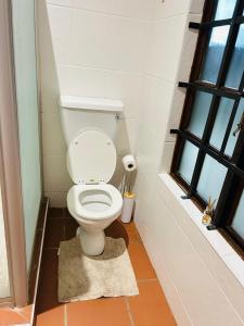 a bathroom with a toilet in a small room at Alwande's Guesthouse in Richards Bay +11 photos