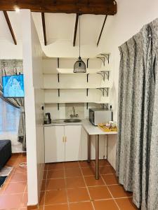 a kitchen with white cabinets and a table with a microwave at Alwande's Guesthouse in Richards Bay