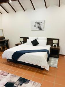 a bedroom with a large bed and a piano at Alwande's Guesthouse in Richards Bay
