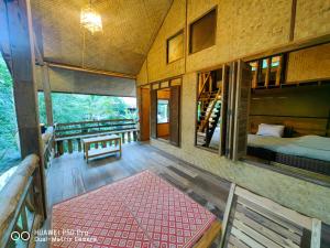 a room with a bedroom and a bed and a balcony at ติดธารโฮมสเตย์ - Cabin by The stream in Ban Nong Chaeng