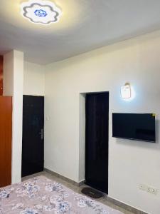 a room with two black doors and a flat screen tv at Sam Apartment 