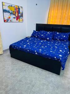 a bed with a blue comforter on it in a bedroom at Sam Apartment 