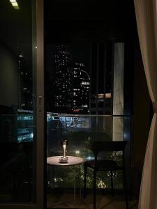 a table and chairs in a room with a window at 1minBTSThonglor:NearEmDistrict|Balcony|Washer|WiFi in Khlong Toei