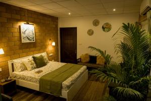 une chambre avec un lit et une plante dans l'établissement Happy Haven Farmstay, à Mangalore