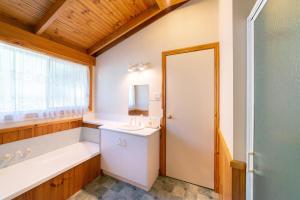 a bathroom with a tub and a sink and a mirror at Awonga Cottages in Halls Gap +22 photos