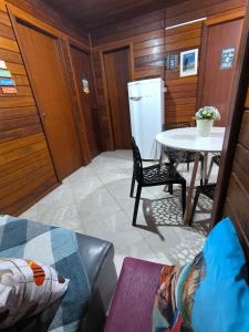 Cantinho do Sonho - Chalé Areia في باليوسا: غرفة معيشة مع طاولة وثلاجة