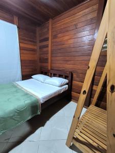 Cantinho do Sonho - Chalé Areia في باليوسا: سرير في غرفة بجدران خشبية +15 صورة