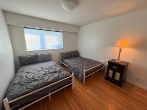 En eller flere senge i et værelse på Vancouver Guest House - Airport & Downtown 15 Min - Free Parking & Fast Wi-Fi