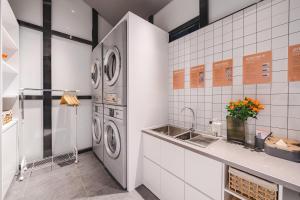 Atour S Hotel Wuxi Nanchang Street في ووشي: مطبخ مع غسالة ومغسلة +66 صورة