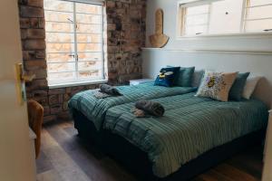 a bedroom with a bed with pillows on it at Fabella Serenety Flat in Muizenberg