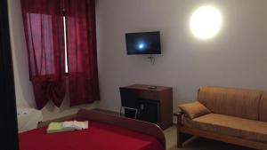 ein Wohnzimmer mit einem Sofa und einem TV an der Wand in der Unterkunft B&B Cuciti in Milazzo