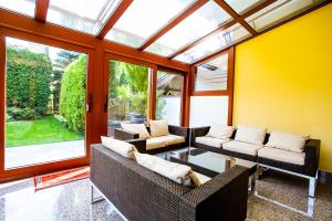 a conservatory with a table and chairs and windows at Apartamenty SaltApart in Wieliczka