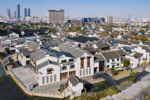 Atour S Hotel Wuxi Nanchang Street في ووشي: اطلالة جوية على صف من البيوت