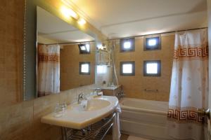 a bathroom with a sink and a mirror and a tub at Victory Byblos Hotel & Spa in Jbeil