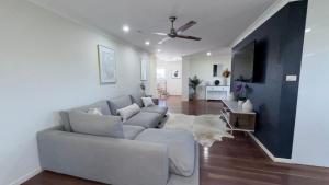 a living room with a couch and a tv at Station on Pearce in Coffs Harbour