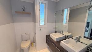 a bathroom with two sinks and a toilet and a mirror at Station on Pearce in Coffs Harbour +17 photos