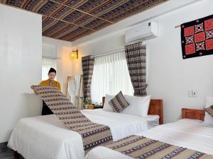 En eller flere senge i et værelse på Mai Chau Bamboo Homestay