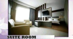a living room with a bed and a room with a couch at Hotel Harmoni Tasikmalaya in Tasikmalaya