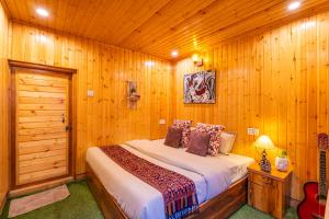 a bedroom with a bed in a wooden room at Himtrek Stays Katagala in Kasol
