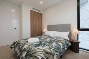 1 dormitorio con 1 cama grande con manta tropical en Luxe 3-bedroom Townhouse in Miranda underground parking, en Miranda