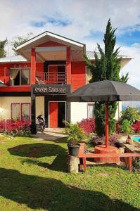 a house with an umbrella and a bench in front of it at Elle Maya Sari in Kotabaru