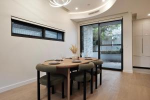 Un comedor con mesa y sillas de madera. en Luxe 3-bedroom Townhouse in Miranda underground parking, en Miranda