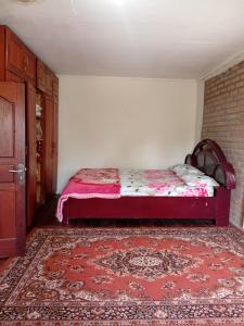 a bedroom with a bed and a red rug at Elle Maya Sari in Kotabaru