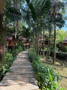 a walkway in front of a resort with palm trees at Bamboo Hideaway Resort in Ko Mak