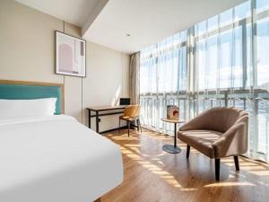 Una cama o camas en una habitación de GreenTree Inn Yichun Mingyueshan Airport 224 fotos más