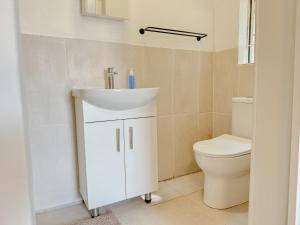 a bathroom with a sink and a toilet at Berrybliss Guesthouse - Sandton in Sandton +8 photos