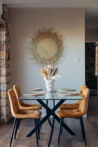 a dining room table with chairs and a vase on it at Fabella Serenety Flat in Muizenberg