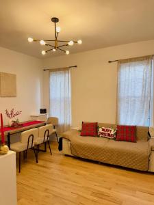 a living room with a bed and a dining table at Spacious 3BR Apartment - 12min Newark Airport -Near NYC & Malls in Newark