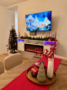 a living room with a christmas tree and a television at Spacious 3BR Apartment - 12min Newark Airport -Near NYC & Malls in Newark