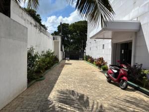 Un scooter rojo estacionado al lado de un edificio en Sj Hotel Jaffna, en Jaffna